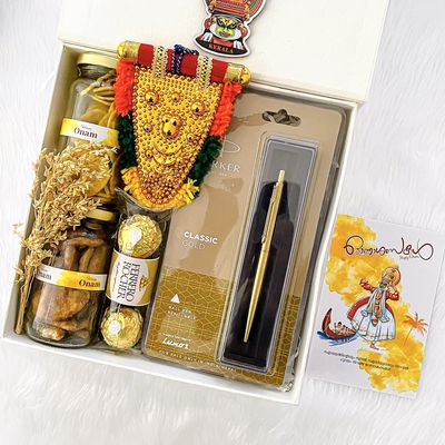 Angroos Kerala Onam wishes and hamper contains banana chips 75g, jaggery chips 75g, parker classic gold, Ferraro Rocher 3 pieces, kathakali sticker, handcraft nettipattam and Kerala Onam greeting card
