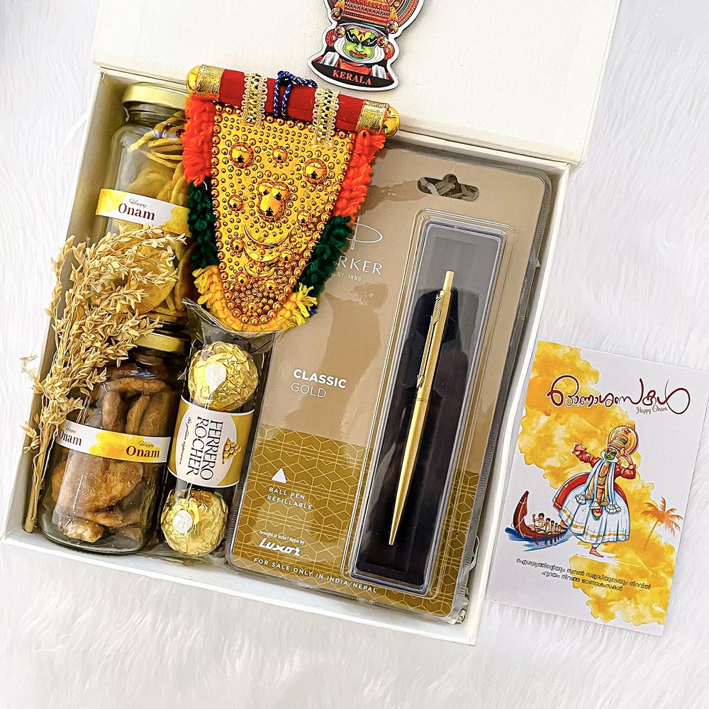 Angroos Kerala Onam wishes and hamper contains banana chips 75g, jaggery chips 75g, parker classic gold, Ferraro Rocher 3 pieces, kathakali sticker, handcraft nettipattam and Kerala Onam greeting card