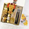 Angroos Kerala Onam wishes and hamper contains banana chips 75g, jaggery chips 75g, parker classic gold, Ferraro Rocher 3 pieces, kathakali sticker, handcraft nettipattam and Kerala Onam greeting card view 1