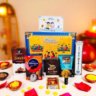 NU LIVING Rakhi Gift Combo Box for Brother Bhaiya & Bhabhi-9 Inclusions + Evil Eye Rakhi Nazar Kavach|Chocolate,Millet Namkeen,Almond Bar,Incense Sticks & Stand,Perfume,Coin,Card,Roli Chawall
