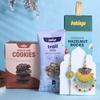 FlowerAura Premium Handcrafted Multicolored Drop Bhaiya Bhabhi Rakhi With Choco Chip Cookies, Trail Mix & Hazelnut Rocks Include Roli Chawal Set - Rakhi Gift Hamper For Bhaiya Bhabhi & Cousins view 1